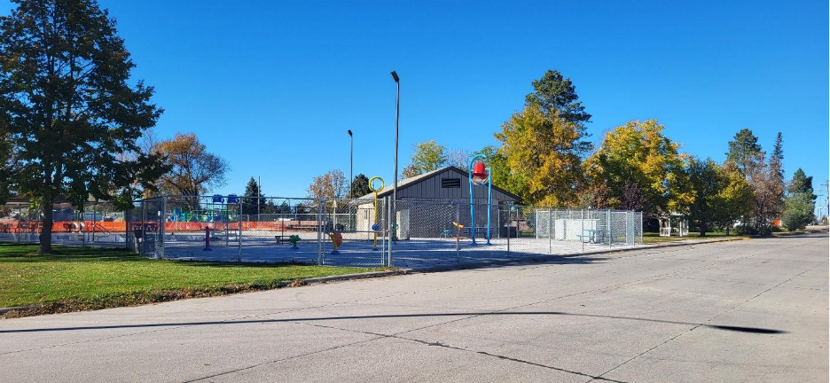A building with trees and a fence AI-generated content may be incorrect_ an image of a street with clouds overhead